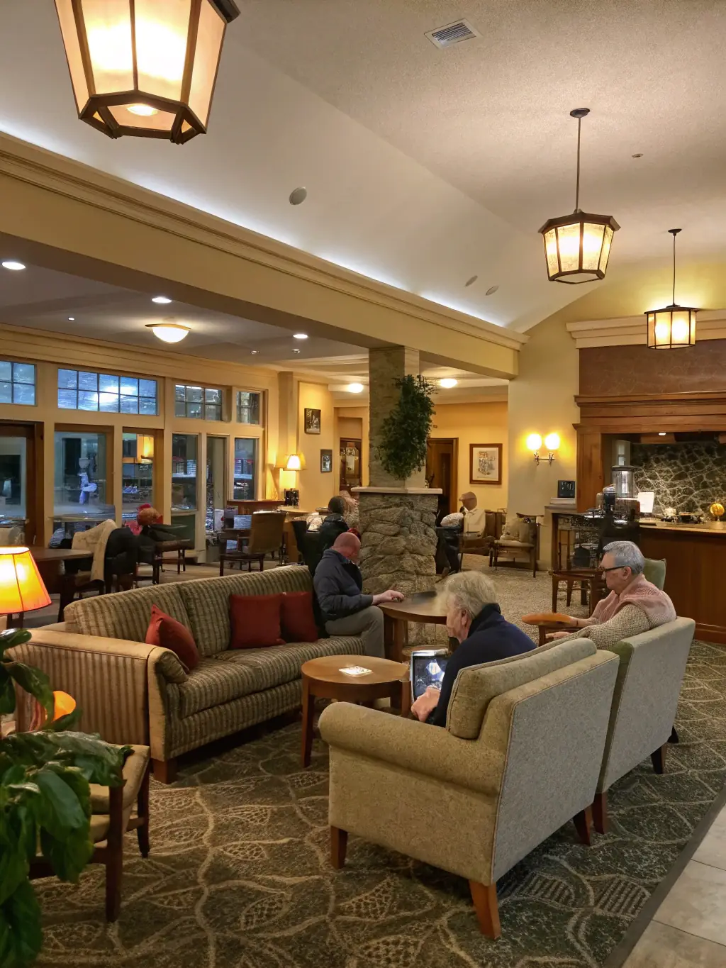 A stylishly decorated community lounge with comfortable seating, a fireplace, and a coffee bar, promoting social interaction.